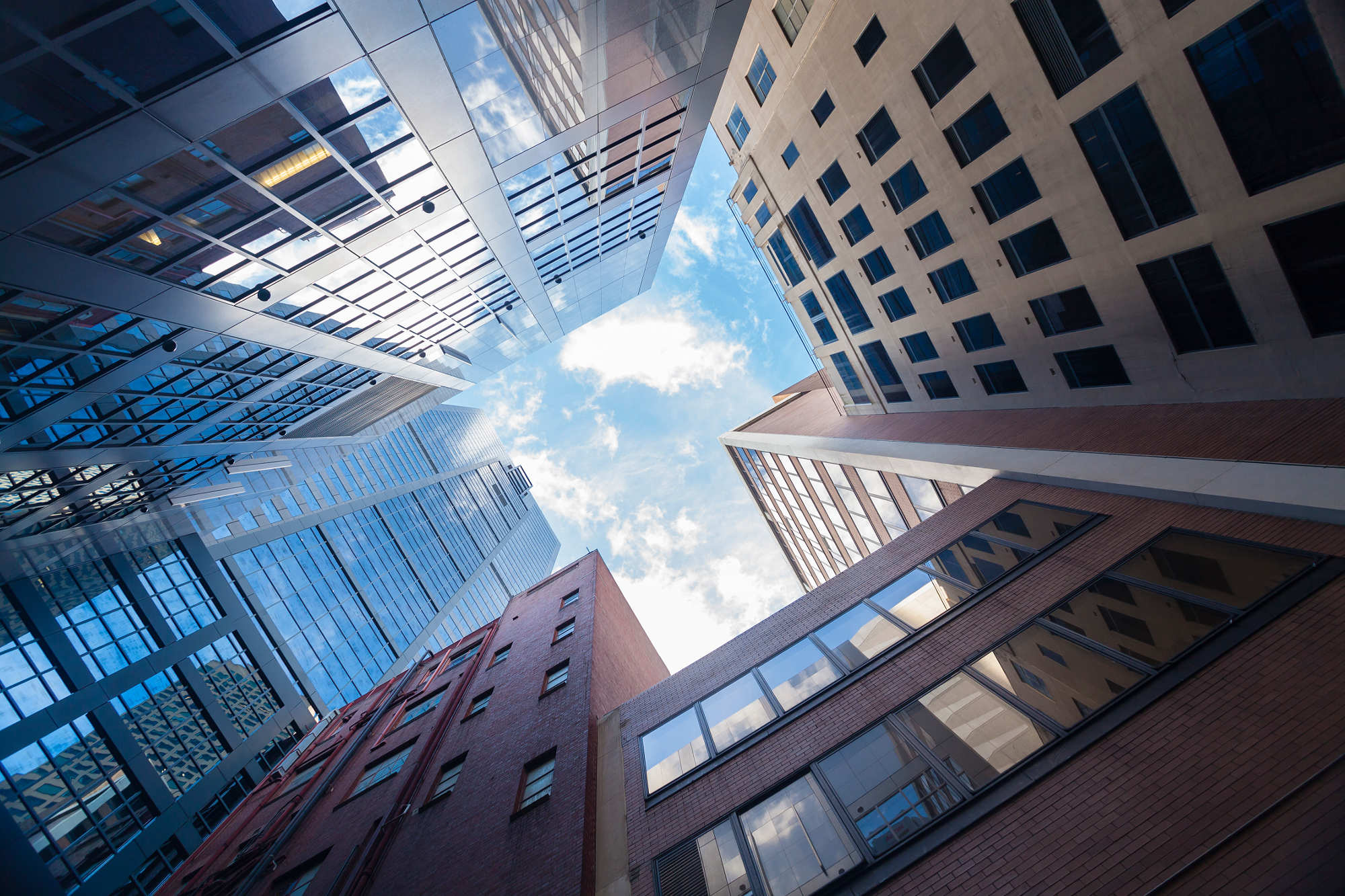 Upward view of skyscrapers against a blue sky