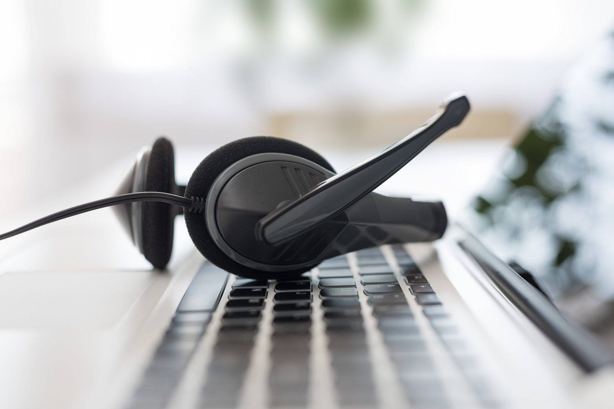 Close up of a VoIP headset resting on a laptop keyboard