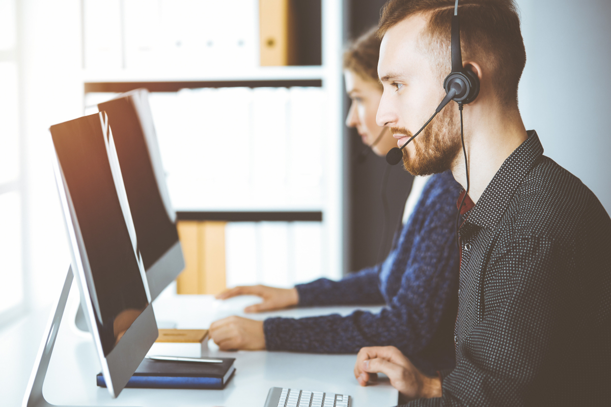 Help desk worker sitting at their desk with a headset on