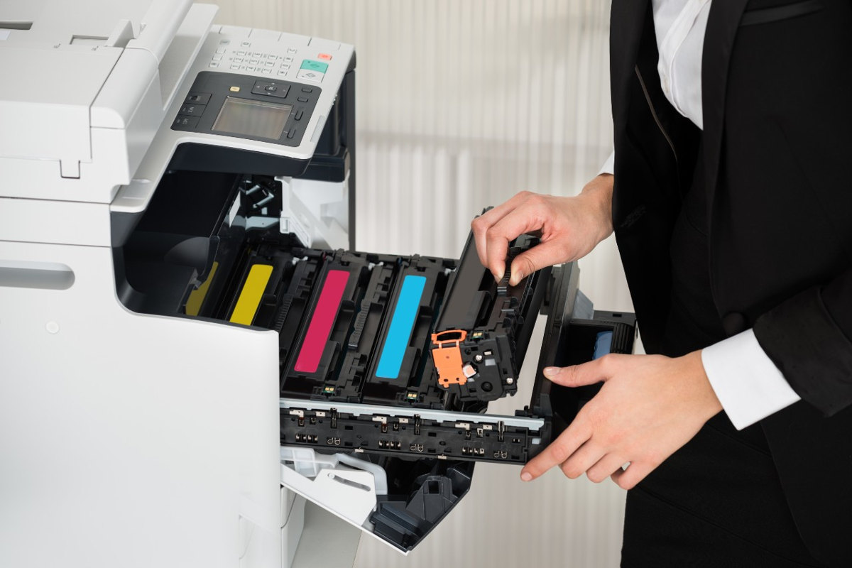 Woman changing toner in an office print copy machine