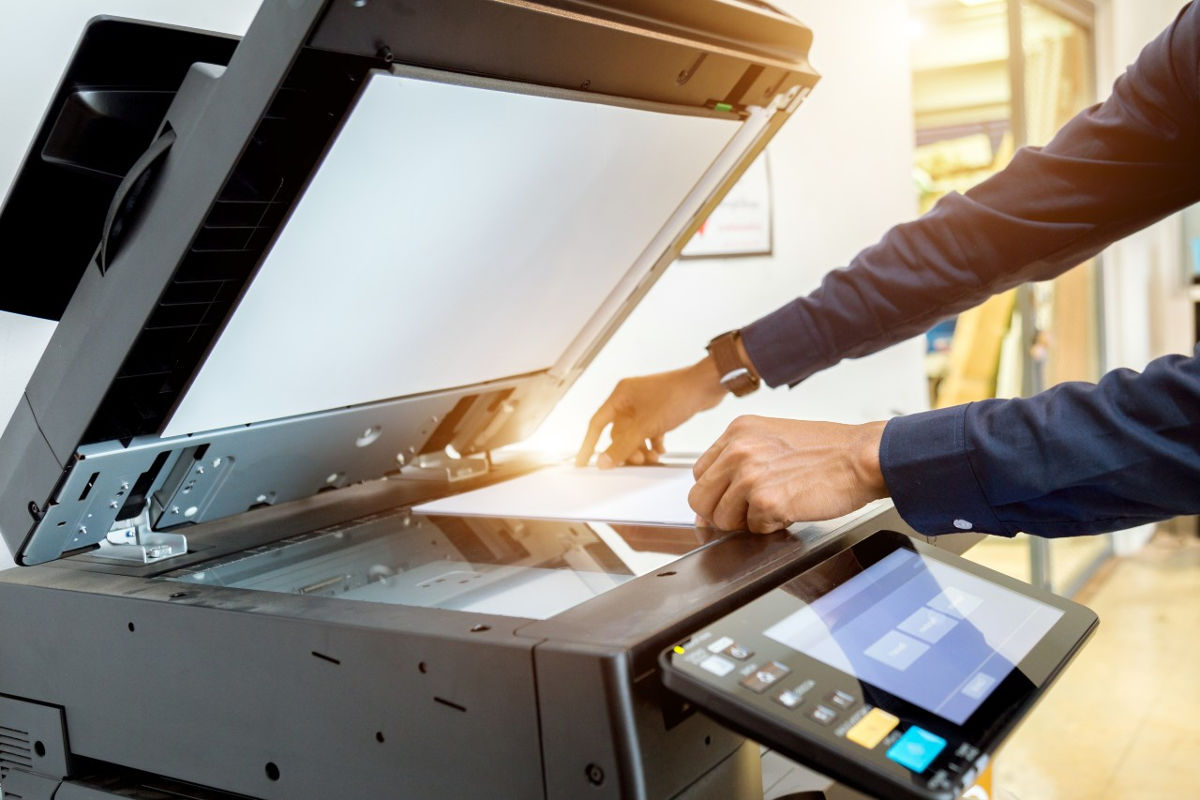 Close up of man using an office print copy machine